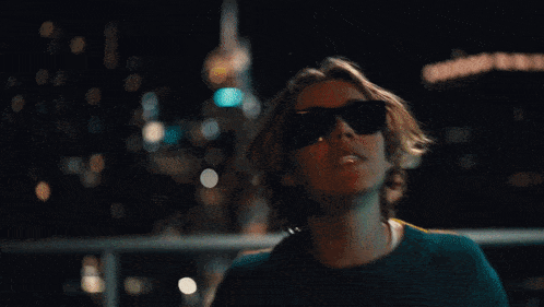 a man in sunglasses stands in front of a ceiling that has the word coca cola on it