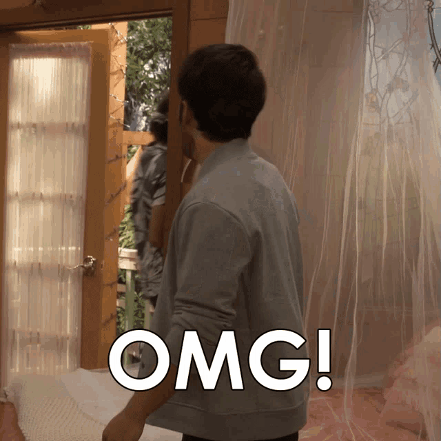 a man is standing in front of a door with the word omg written on it
