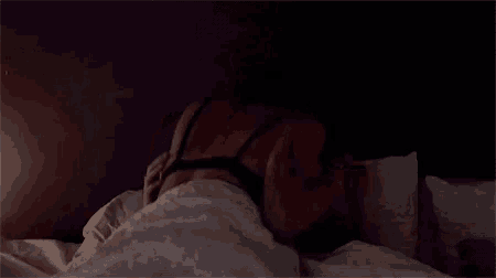 a woman in lingerie is laying in a bed