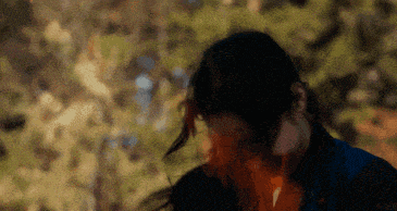 a close up of a person 's face with trees in the background