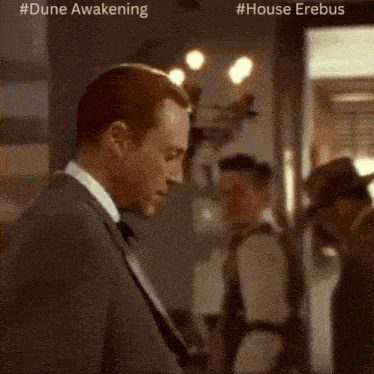 a man in a suit and tie is standing in a room with a caption that says dune awakening and #house erebus