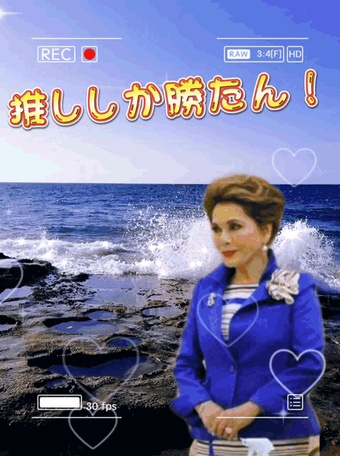 a woman in a blue jacket is standing in front of a body of water with the words raw 3 : 4f1 hd below her