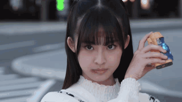 a girl in a white sweater is holding a can that says ' coca cola ' on it