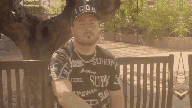 a man wearing a black shirt that says supreme