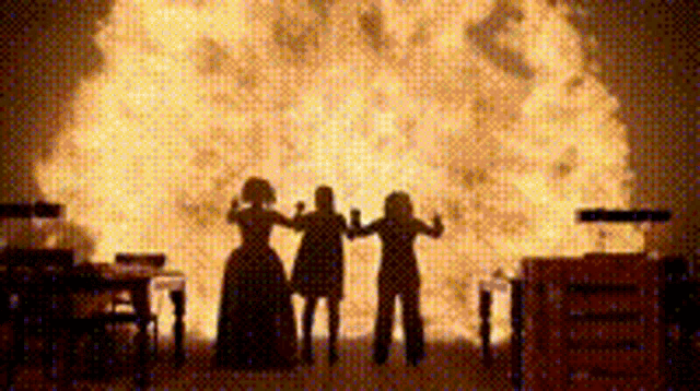 a group of people standing in front of a large fireball .