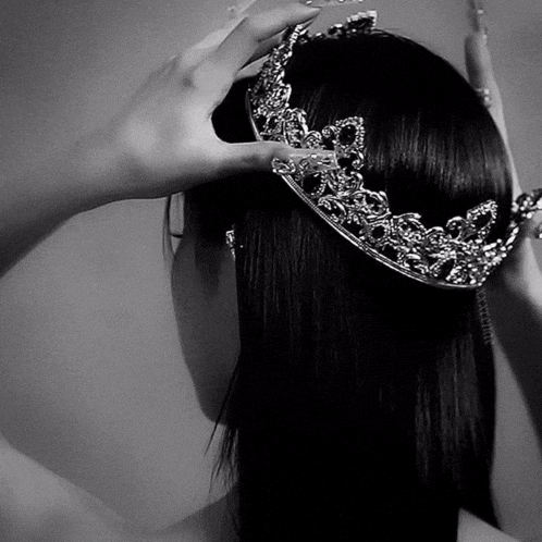 a woman wearing a crown on her head in a black and white photo