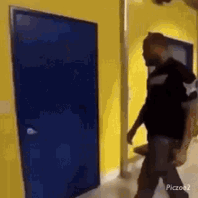 a man is standing in front of a blue door .