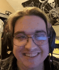 a young man wearing glasses and headphones is smiling .