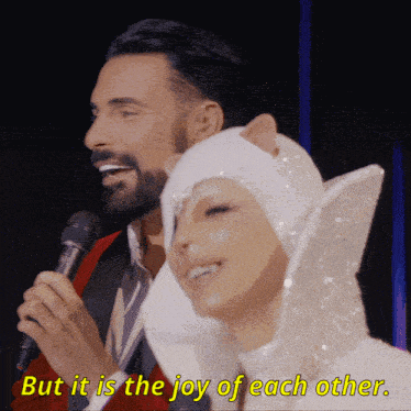 a man holding a microphone next to a woman with the words but it is the joy of each other in yellow letters