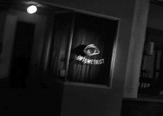 a black and white photo of an optometrist 's shop window
