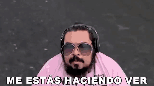 a man with a beard is wearing headphones and sunglasses and says `` me estas haciendo ver '' .