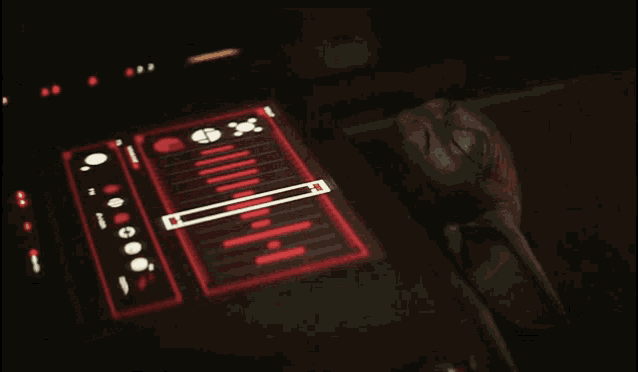 a green alien laying on a table with a display that says ' a ' on it