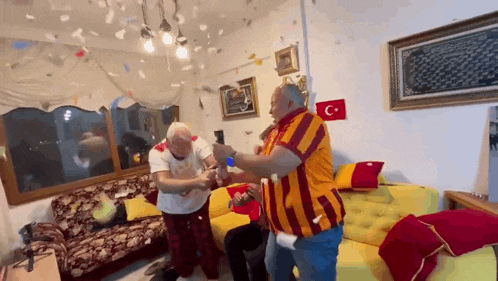 a group of people are playing a game in a living room with a flag on the wall .