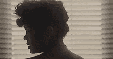 a silhouette of a woman standing in front of a window .