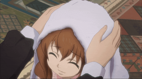 a person holding a girl 's head with a white towel on it