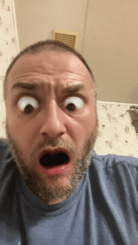 a man with a beard making a surprised face