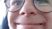 a close up of a person wearing glasses making a funny face