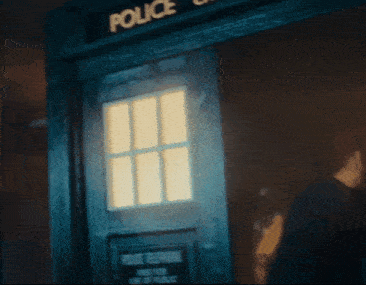 a police telephone booth with a light shining through the window