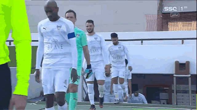 a group of soccer players wearing white jerseys with the word brave on the front