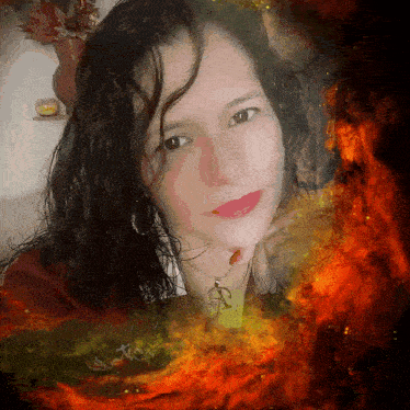 a woman wearing a necklace with the letter a on it is surrounded by flames