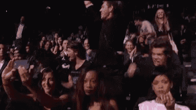 a group of people are sitting in a stadium watching a show .