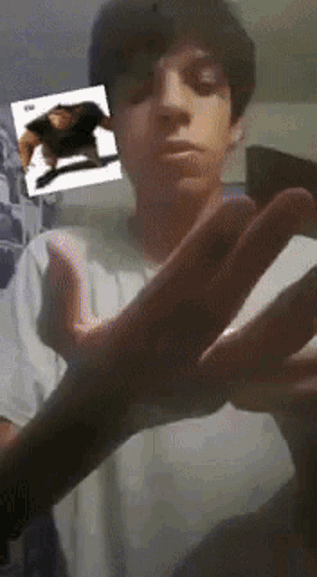 a young man is holding his hands out in front of a picture of a man
