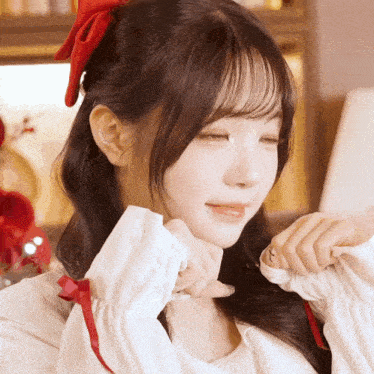 a girl with a red bow in her hair is making a funny face