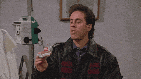 a man in a leather jacket is holding a bag of m&ms