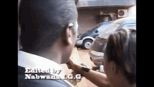 a man and a woman are standing in front of a car with the words edited by nabwana g.g.