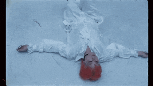 a person with red hair is laying on the ground with fragile written on the ground