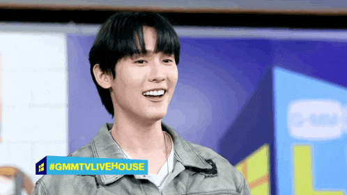 a young man stands in front of a sign that says gmntvlivehouse