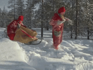 a couple of people in red clothes are standing in the snow
