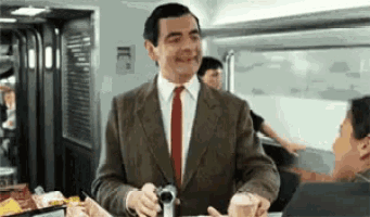 a man in a suit and tie is smiling while holding a camera