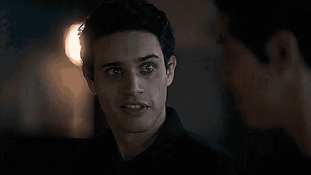 a man in a black shirt is looking at another man .