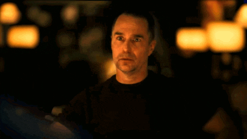 a man in a black shirt looks at the camera