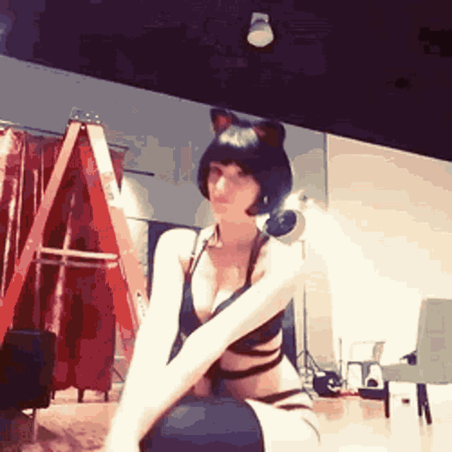 a woman in a cat costume is sitting on the floor in front of a ladder