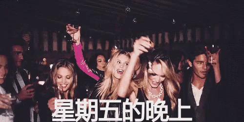 a group of people are dancing in a dark room with chinese writing