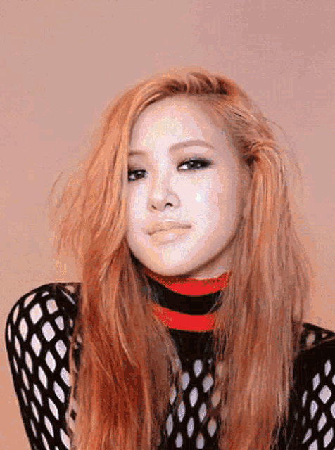 a woman with long blonde hair is wearing a black mesh top and a red and white striped turtleneck .
