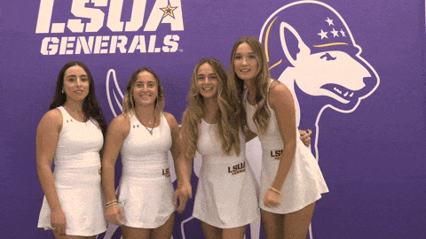 four girls pose in front of a purple lsu generals logo