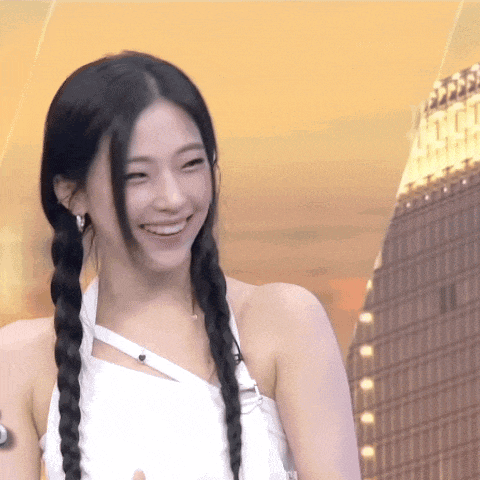a woman with braids is smiling and wearing a white top