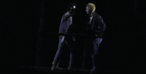 a couple of people are hugging each other in the dark .