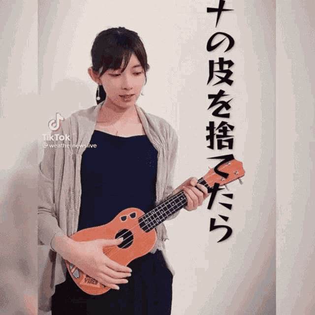 a woman playing an ukulele with a tiktok watermark