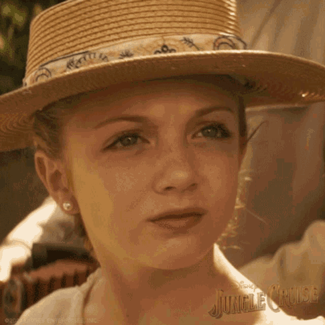 a young girl wearing a straw hat with jungle cruise written on the bottom right
