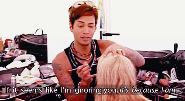 a man applying makeup to a woman with the caption if it seems like i 'm ignoring you it 's because