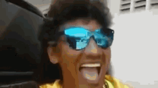 a man wearing sunglasses is sticking his tongue out .