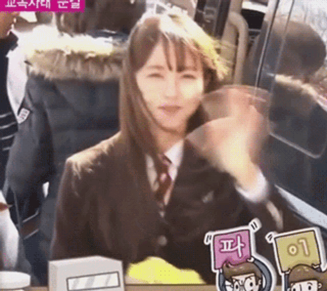 a girl in a school uniform is clapping her hands in front of a sign that says 01