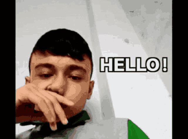 a young man covering his mouth with his hand and the words hello written on the bottom