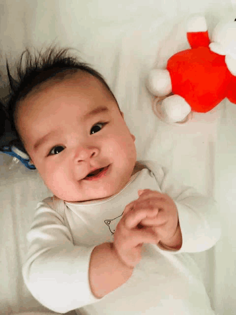 a baby wearing a white shirt with a bear on it