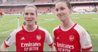 two women wearing emirates fly better jerseys stand next to each other