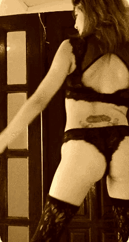 a woman with a tattoo on her back is wearing lingerie